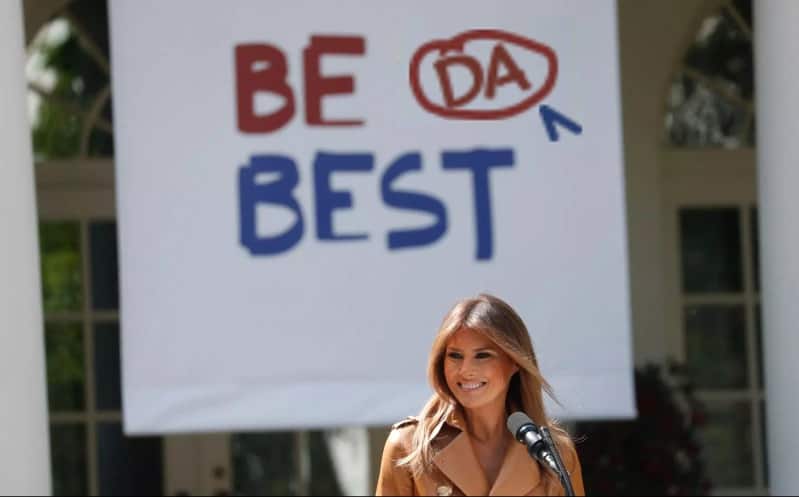 Melania poses in front of new slogan.